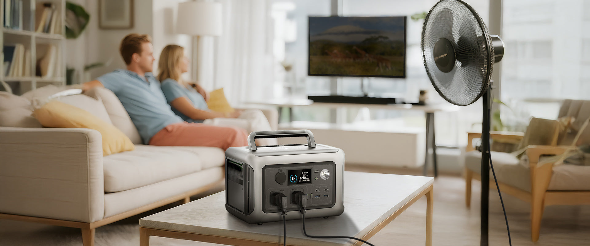 Uma sala de estar aconchegante apresentando uma estação de energia moderna, uma TV e um ventilador, com um casal relaxando no sofá.